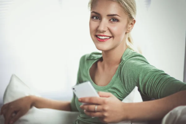 Mujer bonita en su sala de estar acostada en el sofá enviando lío — Foto de Stock