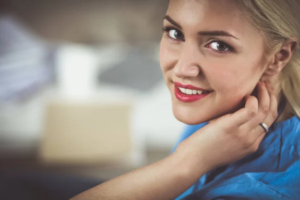 Portrait of a happy young doctor sitting on the sofa — Stock Photo, Image