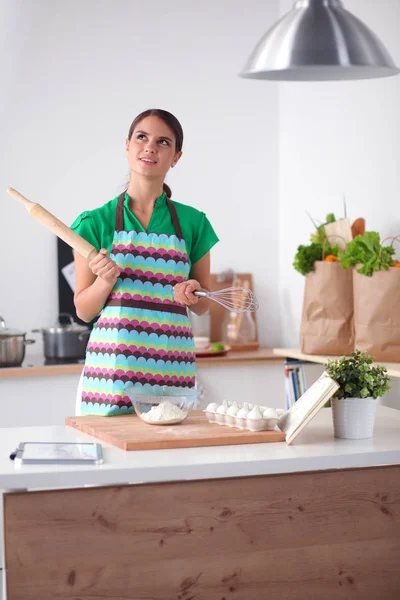 Een jonge vrouw die een boodschappentas met groenten vasthoudt. Staande in de keuken — Stockfoto