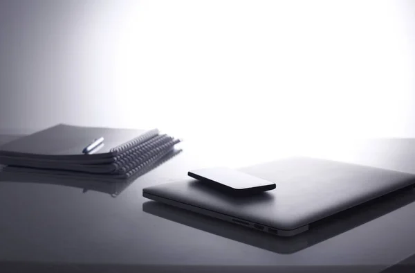 Laptop with stack of folders on table on white background — Stock Photo, Image