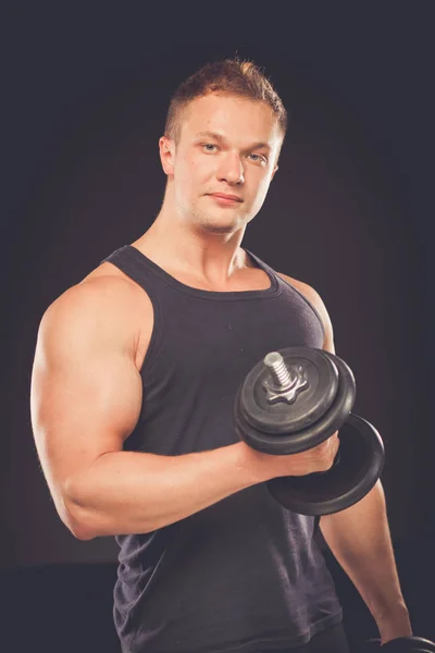 Handsome muscular man working out with dumbbells — Stock Photo, Image