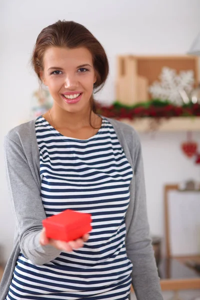 Sorridente giovane donna in cucina, isolata su sfondo natalizio — Foto Stock