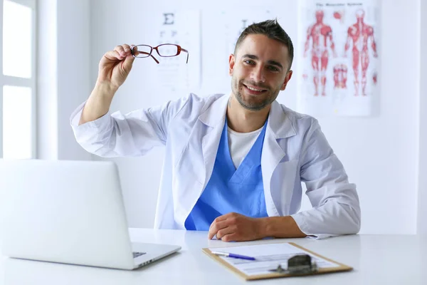 Porträt eines männlichen Arztes mit Laptop am Schreibtisch in der Arztpraxis — Stockfoto