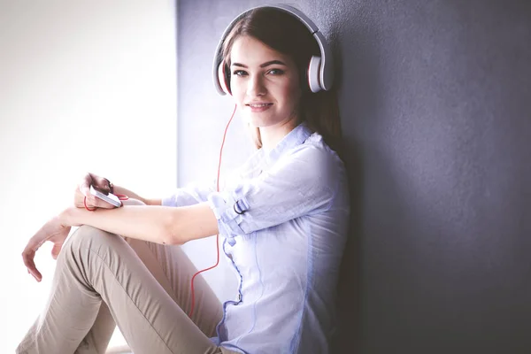 Giovane ragazza felice seduta sul pavimento e ascoltare musica — Foto Stock