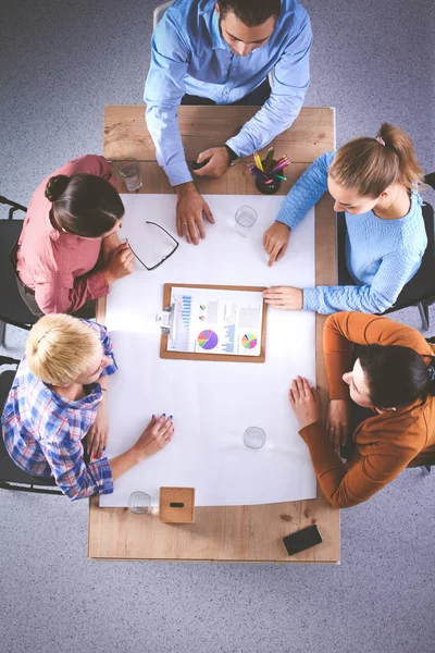 İş adamları toplantıda, ofiste oturup tartışıyorlar.