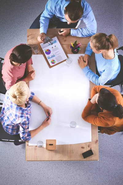 İş adamları toplantıda, ofiste oturup tartışıyorlar.