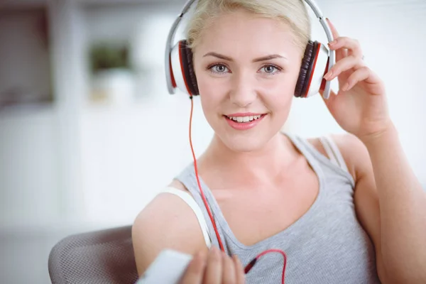 Joven hermosa mujer en casa sentada en el sofá y escuchando música —  Fotos de Stock