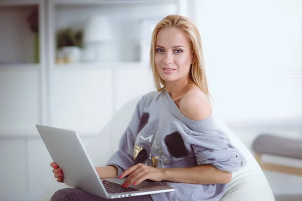 Jovem mulher bonita usando um computador portátil em casa — Fotografia de Stock