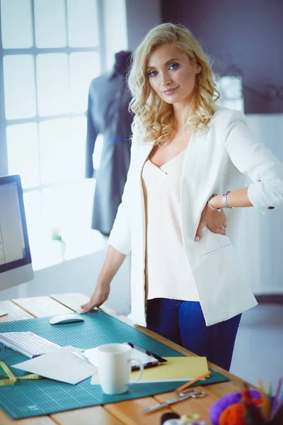 Moda tasarımcısı kadın stüdyoda tasarımları üzerinde çalışıyor.