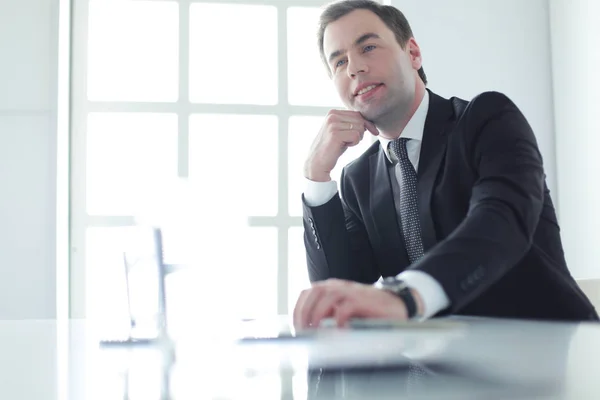 Portrait de jeune homme assis à son bureau dans le bureau. — Photo