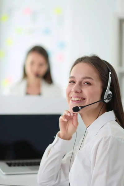 Empresária sorridente ou operador de linha de ajuda com fone de ouvido e computador no escritório — Fotografia de Stock