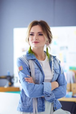 Moda tasarımcısı kadın stüdyoda tasarımları üzerinde çalışıyor.