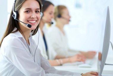 Ofisinde kulaklık ve bilgisayarla gülümseyen iş kadını ya da yardım hattı operatörü