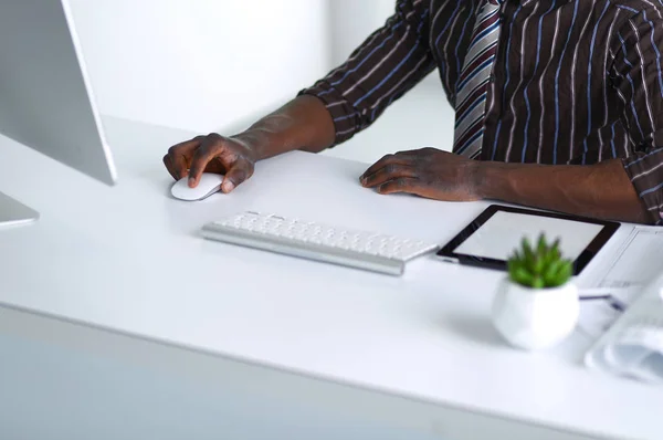 Stilig Afro amerikansk affärsman i klassisk kostym är att använda en laptop och leende medan arbetande i kontor — Stockfoto