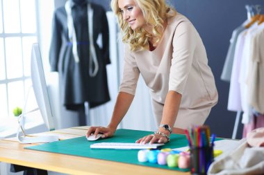 Moda tasarımcısı kadın stüdyoda tasarımları üzerinde çalışıyor.