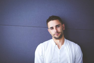 Genç iş adamı beyaz arka planda tek başına duruyor.