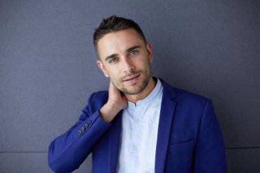 Gri arka planda yalnız oturan genç iş adamı