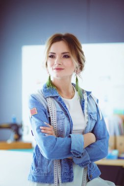 Moda tasarımcısı kadın stüdyoda tasarımları üzerinde çalışıyor.