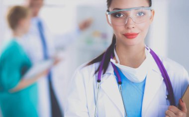 Kadın doktor hastanede dosyayla bekliyor. 