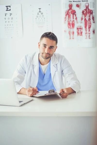 Porträt eines männlichen Arztes mit Laptop am Schreibtisch in der Arztpraxis — Stockfoto