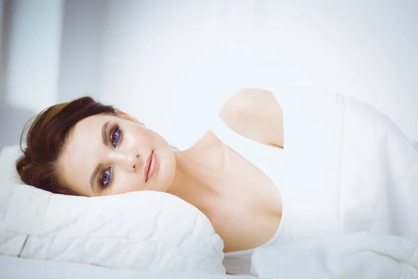 Fiatal gyönyörű nő fekszik az ágyban — Stock Fotó