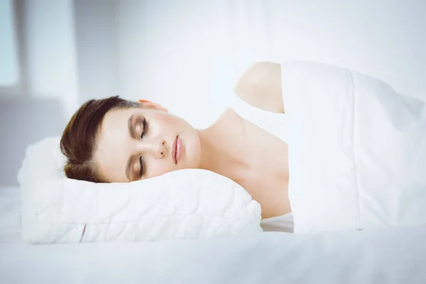 Νεαρή όμορφη γυναίκα ξαπλωμένη στο κρεβάτι — Φωτογραφία Αρχείου