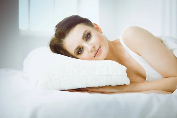 年轻美丽的女人躺在床上 — 图库照片