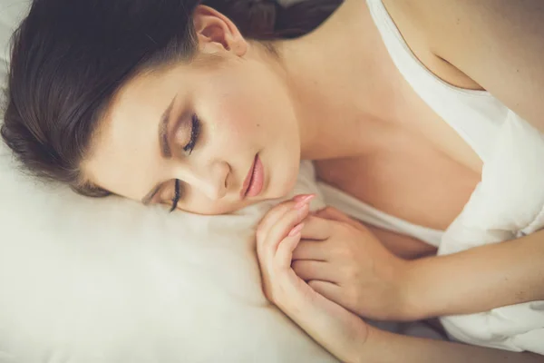 하얀 침대에 누워 있는 아름다운 젊은 여성 — 스톡 사진