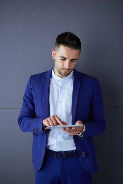 Joven empresario sentado aislado sobre fondo gris — Foto de Stock