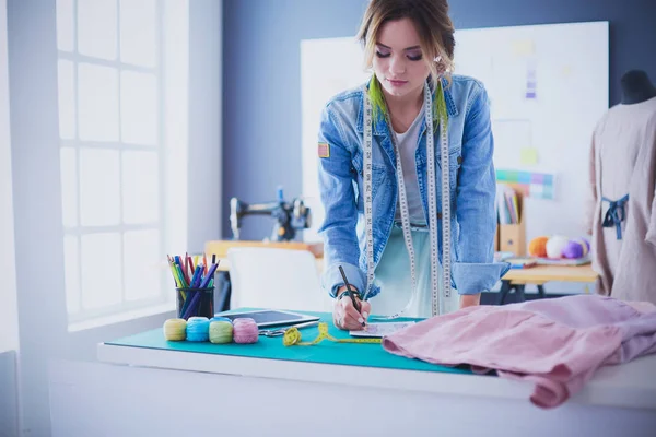 Mulher designer de moda trabalhando em seus projetos no estúdio — Fotografia de Stock