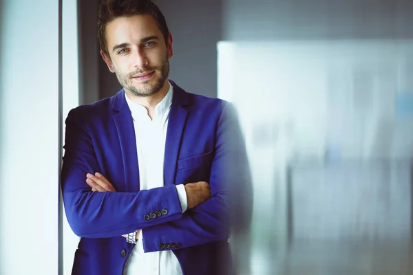 Retrato del joven diseñador frente a la computadora portátil y el ordenador mientras trabaja . — Foto de Stock