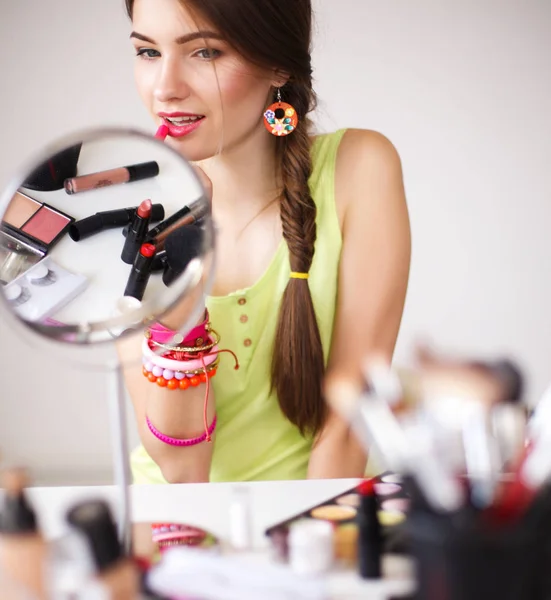 Молода красива жінка робить макіяж біля дзеркала — стокове фото
