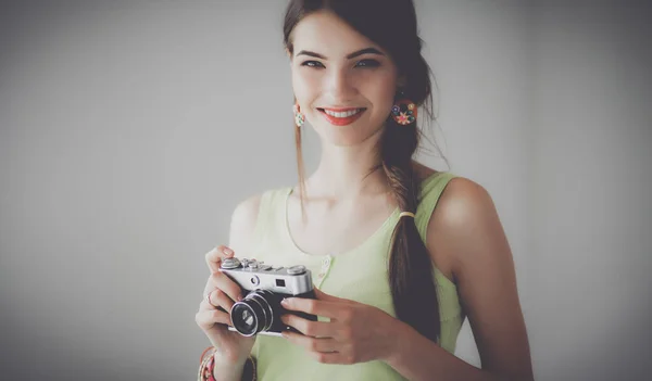 Vacker ung kvinna med kameran står nära mörk vägg — Stockfoto
