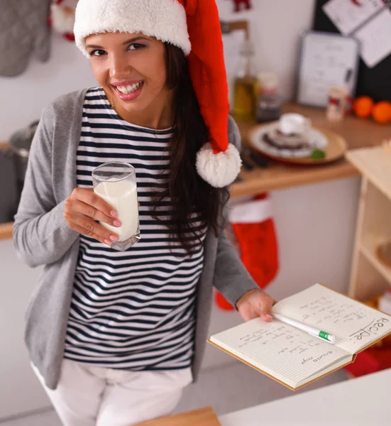 Happy young woman smiling happy having fun with Christmas preparations wearing Santa hat — Stock Photo, Image