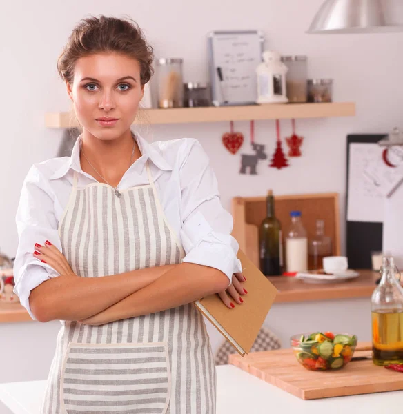 Sorridente giovane donna in piedi in cucina — Foto Stock