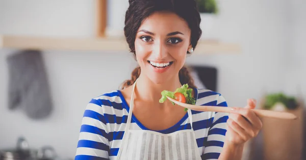 Jeune femme manger de la salade fraîche dans la cuisine moderne — Photo