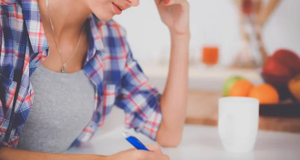 Junge Frau schreibt etwas in ihren Notizblock — Stockfoto