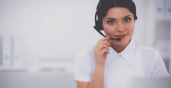 Retrato de mulher de negócios bonita trabalhando em sua mesa com fone de ouvido e laptop — Fotografia de Stock