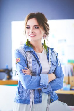 Moda tasarımcısı kadın stüdyoda tasarımları üzerinde çalışıyor.