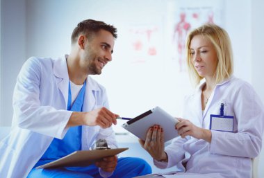 Genç ve kendinden emin doktorların portresi tıp ofisinde duruyor.