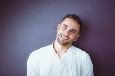 Gri arka planda yalnız oturan genç iş adamı