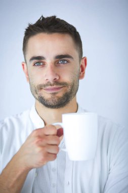 Bir fincan kahve ya da çay içen genç iş adamı.