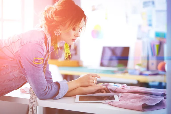 Onun tasarımları s iPad ile çalışan moda tasarımcısı kadın