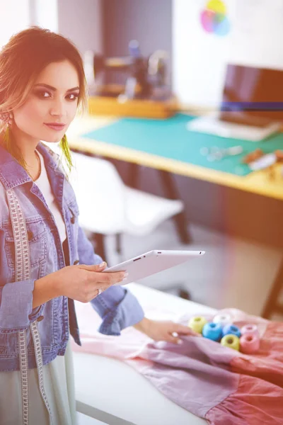 Onun tasarımları s iPad ile çalışan moda tasarımcısı kadın