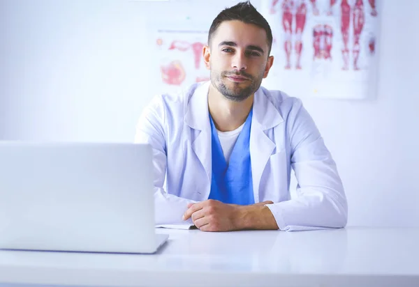 Porträt eines männlichen Arztes mit Laptop am Schreibtisch in der Arztpraxis — Stockfoto