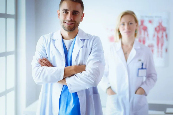 Mladí a sebevědomí lékaři portrét stojící v lékařské ordinaci — Stock fotografie