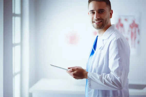 Mladý a sebevědomý mužský lékař portrét stojící v lékařské ordinaci — Stock fotografie