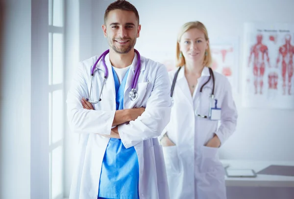 Mladí a sebevědomí lékaři portrét stojící v lékařské ordinaci — Stock fotografie