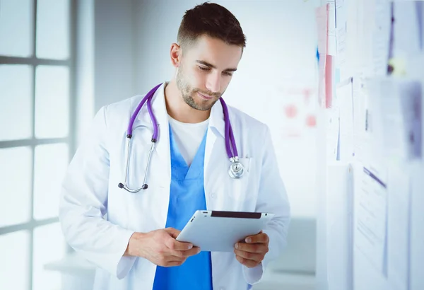 Jovem e confiante retrato médico masculino em pé no consultório médico — Fotografia de Stock