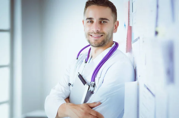 Retrato médico masculino joven y confiado de pie en el consultorio médico — Foto de Stock